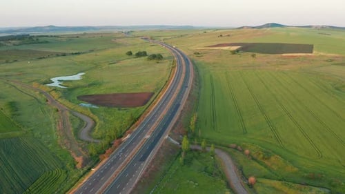 Vue aérienne d'une longue autoroute entourée de champs verts