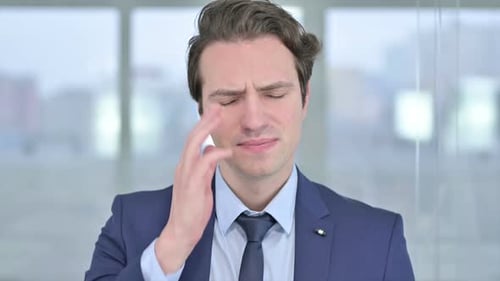 Businessman Rubs Temple with Headache in Close Up