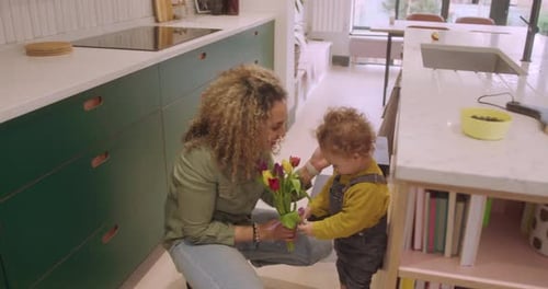 Mother and Child Admiring Tulips in Kitchen