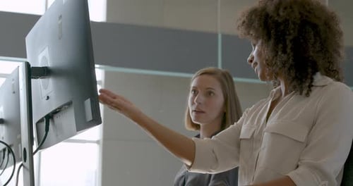 Women Collaborating on Computer in Modern Office