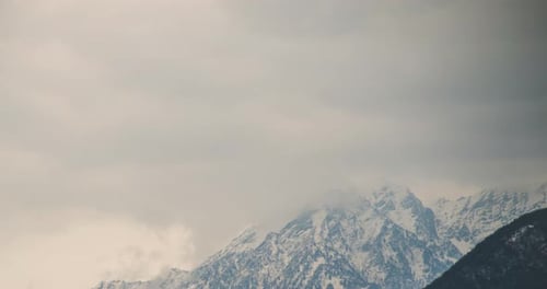 Timelpase of Large Snowy Alpine Mountain with Clouds Moving