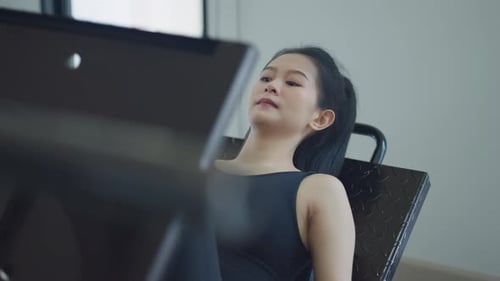 Woman using leg press machine in a modern gym