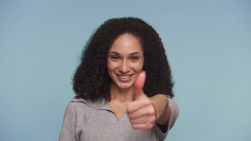 Woman Smiling and Giving a Thumbs Up