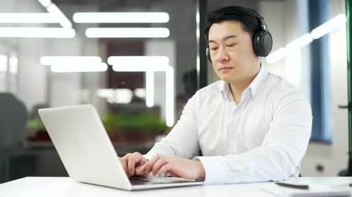 Young Adult Man Working on Laptop in Office