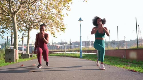 Two Young Women Doing Fitness Exercises in a Park