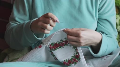 Hands Stitching Floral Fabric with Needle and Thread
