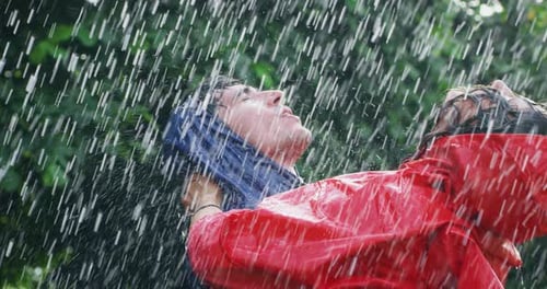 Happy Couple Embracing and Laughing in the Rain