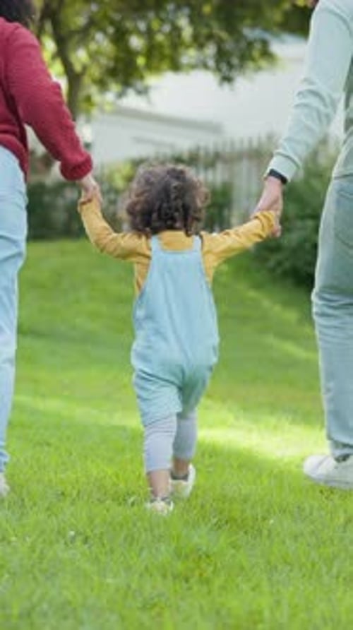 Back, parents and holding hands with child outdoor for travel, love and bonding together