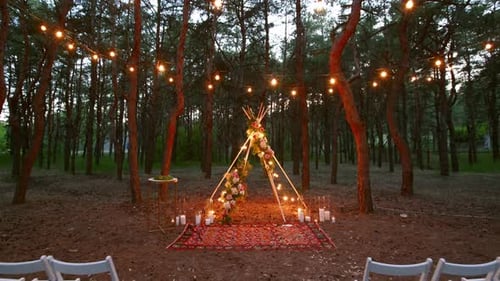 Festive String Lights Illumination on Boho Tipi Arch Decor on Outdoor Wedding Ceremony Venue in Pine
