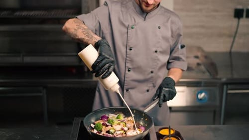 Chef Adding Sauce to Pan of Vegetables
