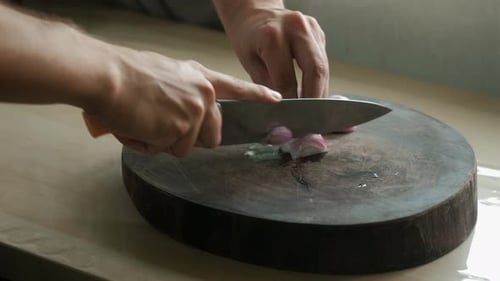 Person Chopping a Red Onion in a Kitchen