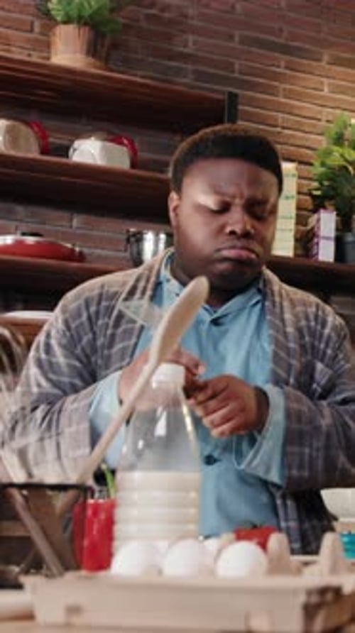 Young Adult Sings with Spatula in Kitchen