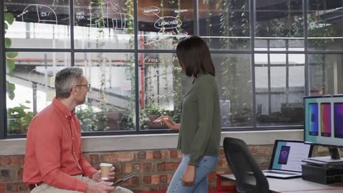 Diverse male and female colleagues brainstorming at glass wall in office, slow motion