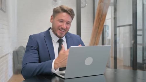 Man on Laptop Video Call in Office