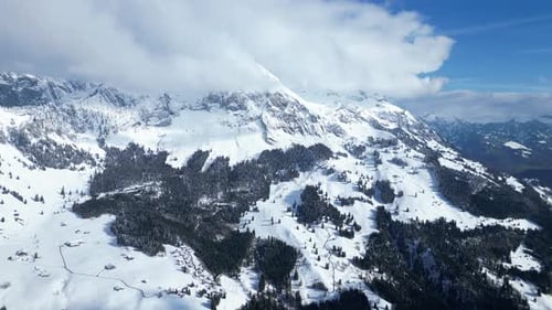 Moving aerial shot of snow covered Fronalpstock mountains in Glarus, Switzerland.