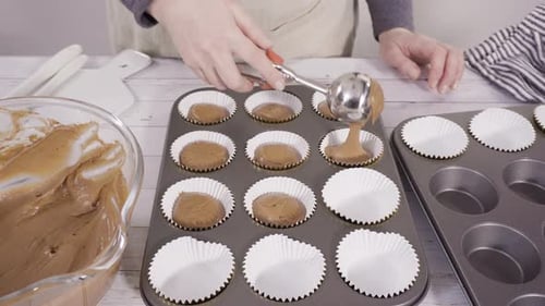 Scooping Dough Into the Foil Cupcake Liners to Bake Chocolate Raspberry Cupcakes