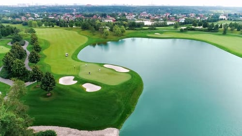 Drone Flies Over a Large Golf Course with Lakes on a Clear Summer Day
