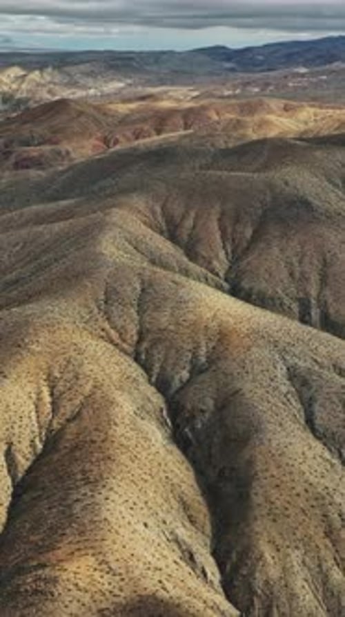 Aerial view of Nevada's rugged terrain with rolling hills and shadows