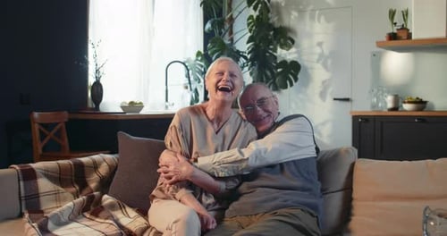 Senior Couple Embracing on Living Room Couch