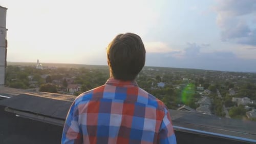 Man on Rooftop Celebrating at Sunrise