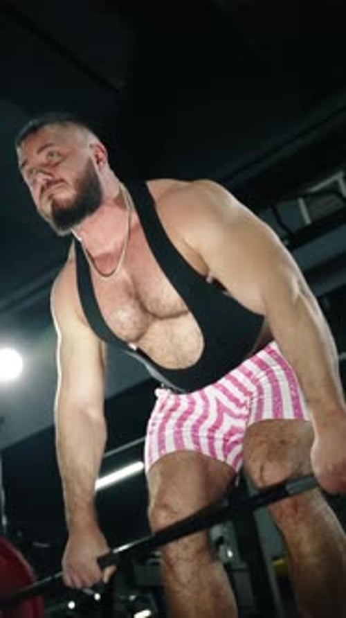 Muscular Athlete Grinding Through a Heavy Barbell Deadlift in a Gym Wearing a Black Singlet and