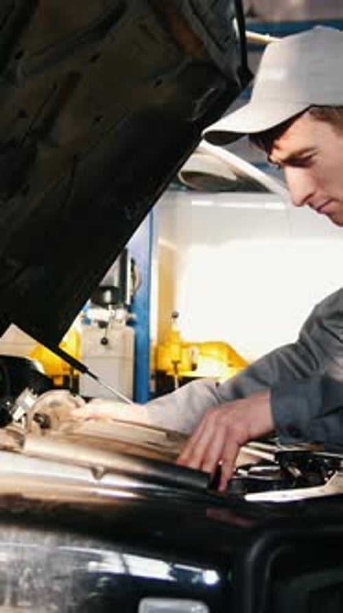 Mechanic Male in Automobile Garage Processing Engine Diagnostic Checking in
