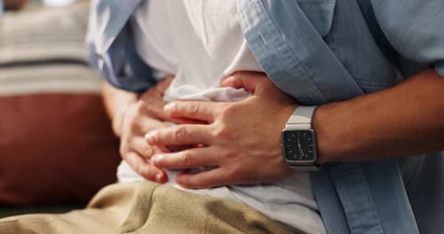 Hands, tummy ache and man on sofa in home for indigestion, diarrhea or food poisoning