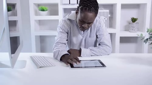 African American Man Working With Tablet Computer In Home Office