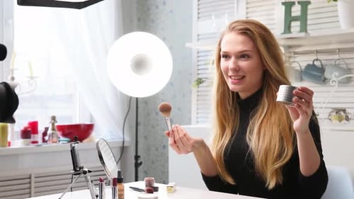 Mujer bloguera de belleza filmando un tutorial diario de rutina de maquillaje ante la cámara en un trípode, la influencer Lady Live