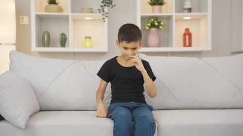 Young Boy Sitting on Couch Making Hand Motions