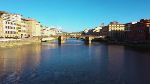 Static aerial view above Arno River and city on a sunny day in Florence in Italy in 4k.
