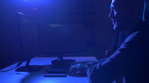 Two Men Programming at Computers in Dark Room