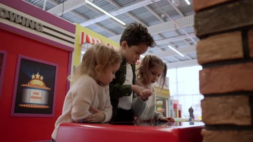 Joyful Little Kids Playing with Touch Screen in Entertainment Center While Exploring Virtuality