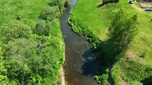 Winding river flowing through a lush green valley and forest