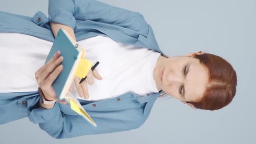 Woman Writes on Sticky Note in Portrait Orientation