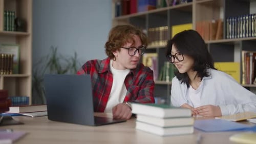 Des étudiants diversifiés étudient ensemble dans une bibliothèque universitaire