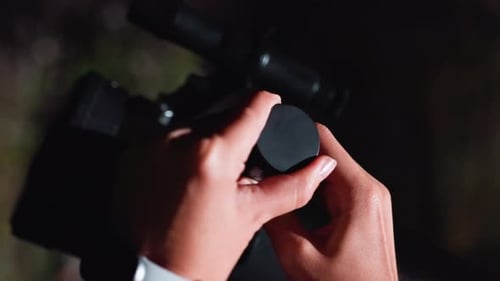 Hands Prepare Telescope for Stargazing at Night