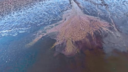 Aerial views of abstract mud patterns and sediment runoff in to the lake