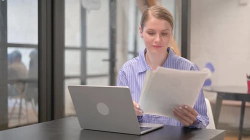Woman Receives Good News at Laptop With Documents