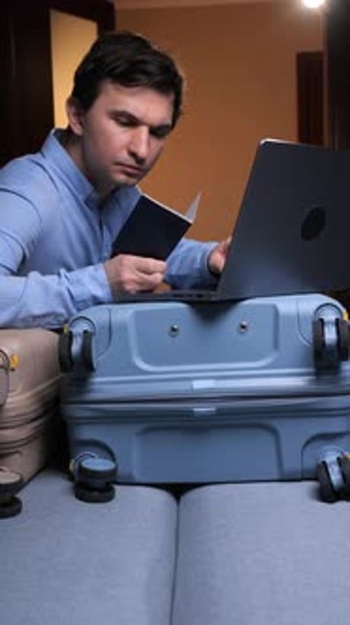 Man with Laptop Prepares for Trip at Home
