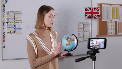 Woman Turning Globus and Recording Online Video at School