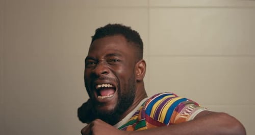 Man Celebrates Raising Arm in Triumph