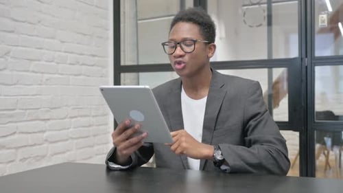 Young African Man Doing Video Chat on Tablet in Office