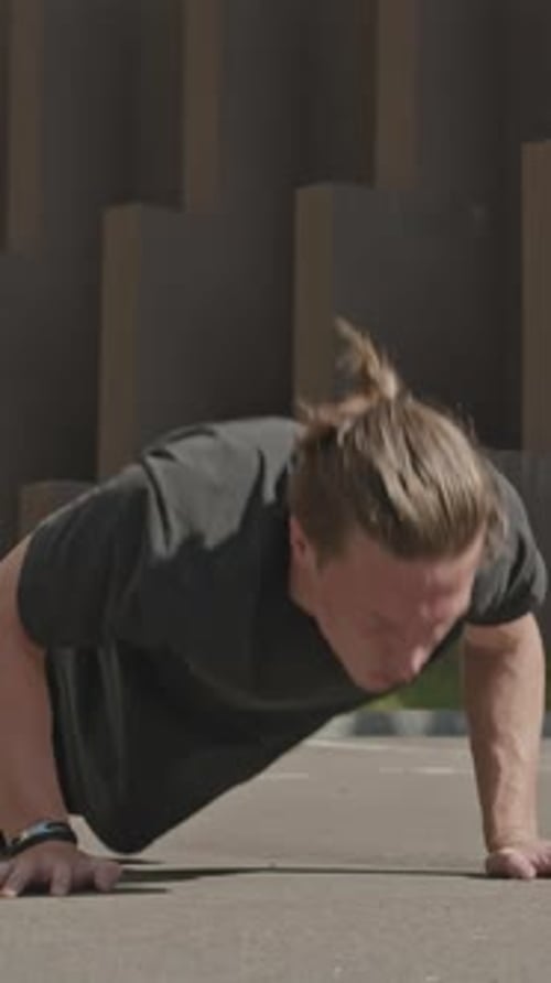 Young Adult Doing Pushups on Urban Street
