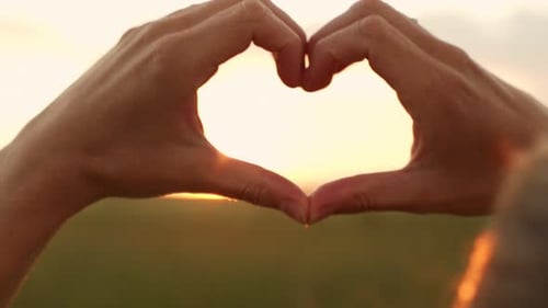 Hands Forming Heart Shape During Golden Hour