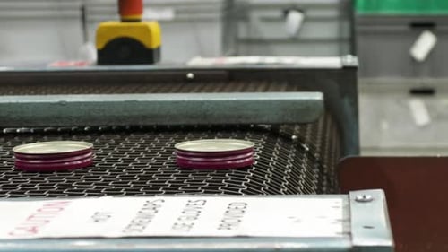Aluminum Caps On The Conveyor Belt System At The Factory. - closeup shot