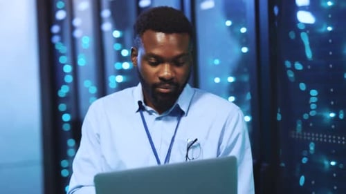Man Working on Laptop in Data Center