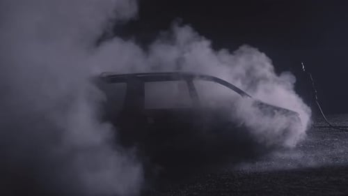 Firefighter Combating a Fire Fireman Putting Out a Burning Car on Flames with Water Hose Filmed on