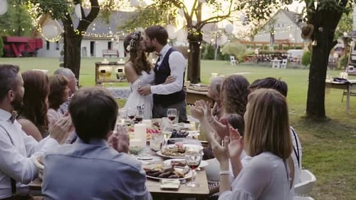 Bride and Groom Kiss at Outdoor Wedding Reception