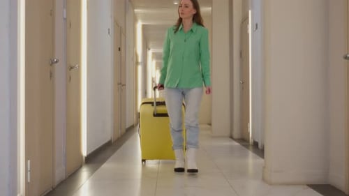 Woman with a Suitcase Walks Down the Corridor of the Hotel a Rear View of a Business Woman During a